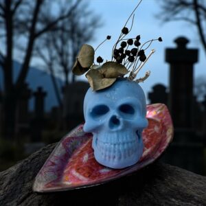 Bougie crâne bleu sur plateau en verre rouge